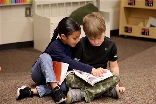 two students reading together.